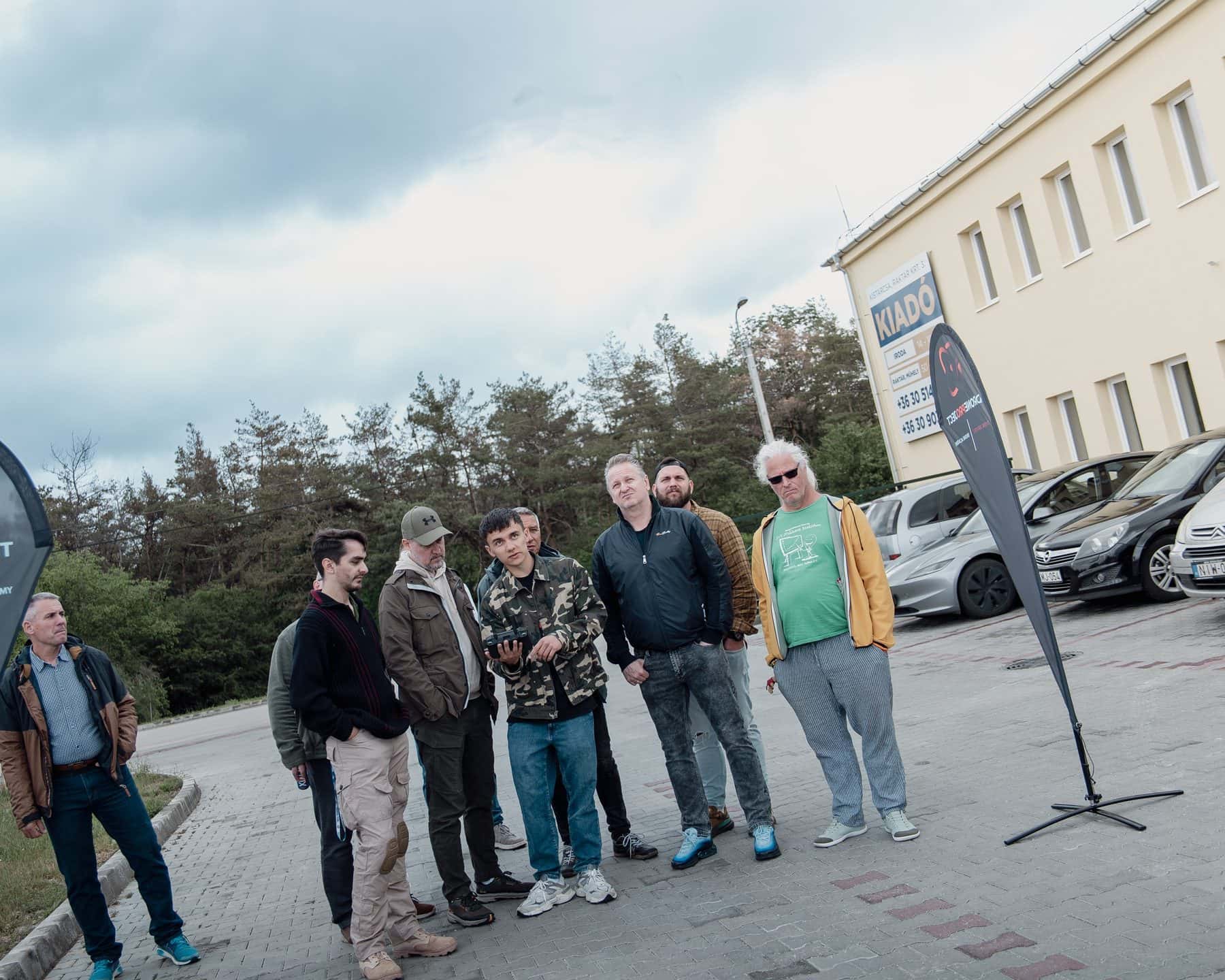 Gyakorlati repülés a képzésen: a csoport a fejük fölött lebegő Mavic 3 drónt figyeli