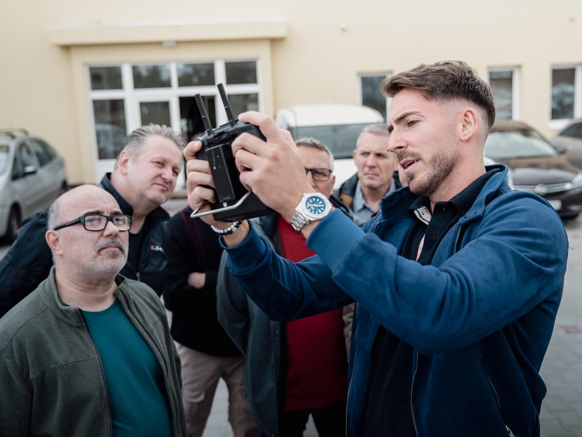 Oktató a résztvevőknek mutatja a kontroller használatát
